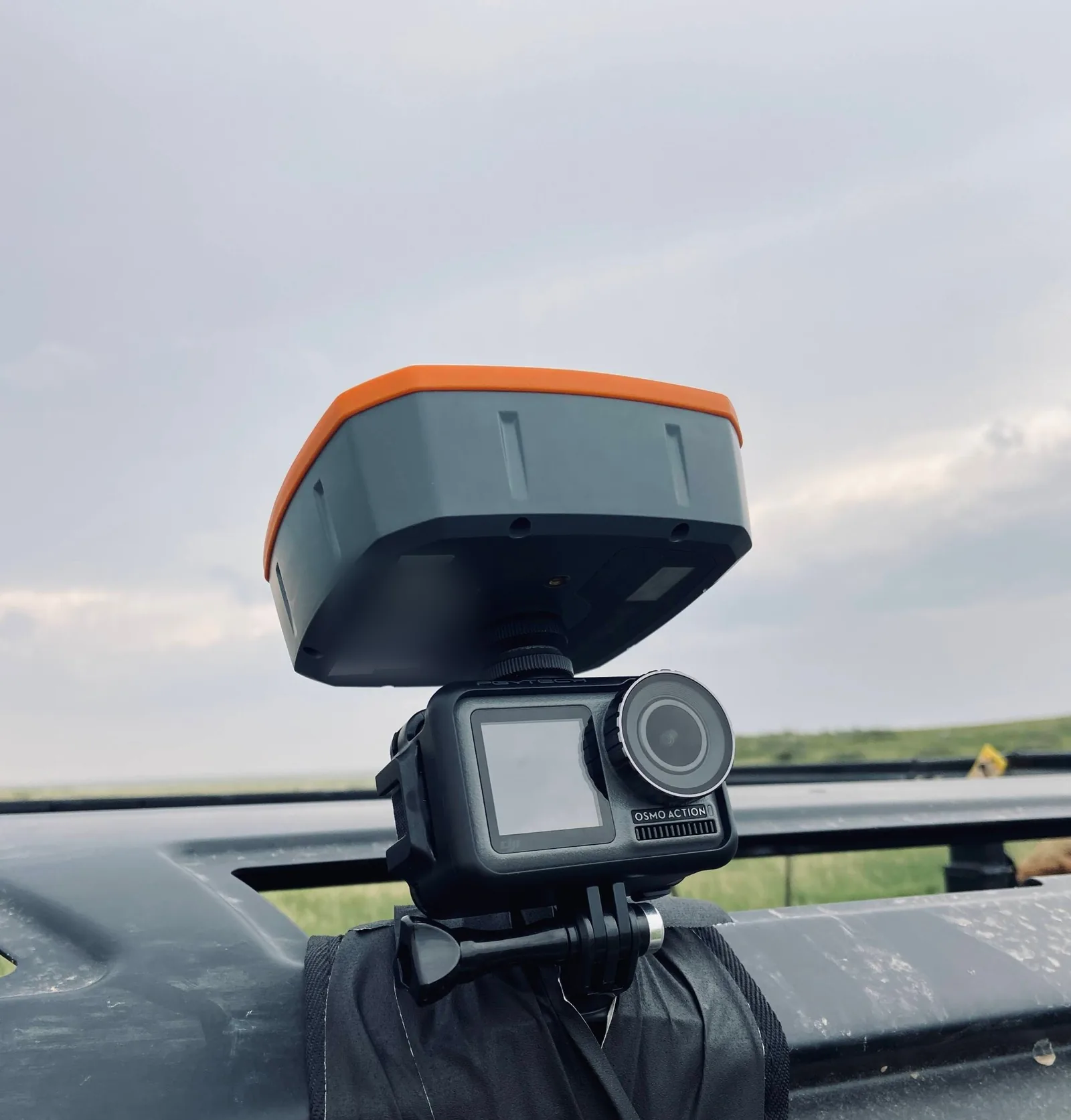 A GNSS receiver mounted on an action camera on an ATV's dashboard rail